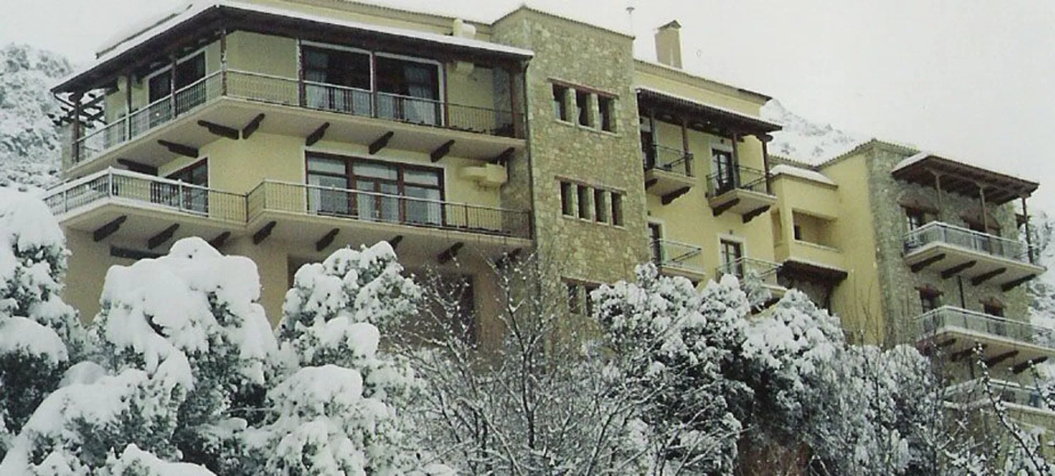 Το ξενοδοχείο με τα μπαλκόνια και τα χιονισμένα δέντρα μπροστά του